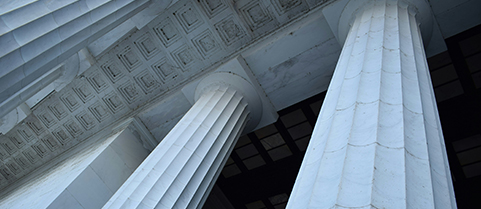 Upward view of large carved stone pillars on a building