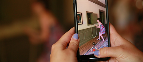 View of a phone while someone is taking a photo of someone ringing the Wren Bell