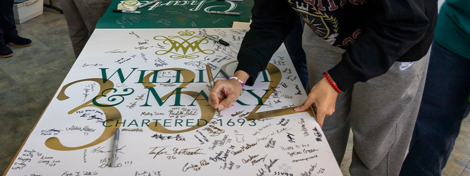 Many signatures on a white banner with a large "332" in golden lettering