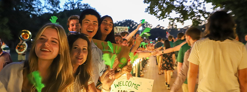 W&amp;M students lined up along barricades smiling, holding signs and green hand-clappers and watching for the new students to walk through for high-fives.