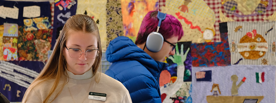 Two people concentrating on their tasks at hand, sitting in front of a colorful mural
