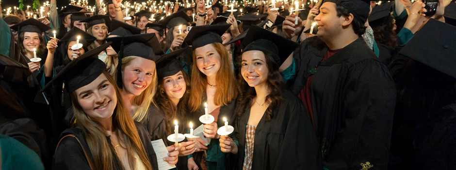 Graduates in full regalia holding candles at the Candlelight ceremony