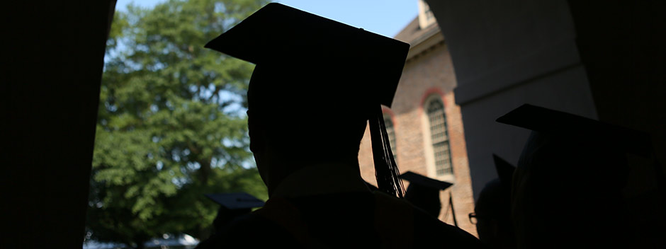Silhouettes of graduates in caps crossing through the Wren portico