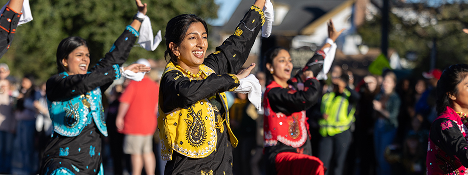 The colorfully attired Griffin Bhangra team performs on a sunny day to parade watchers