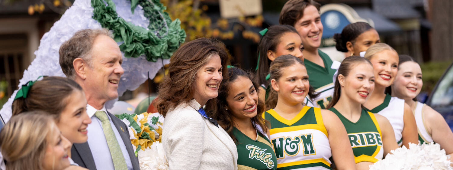 Tribe cheerleaders pose for a photo with President Katherine Rowe and First Gentleman Bruce Jacobson