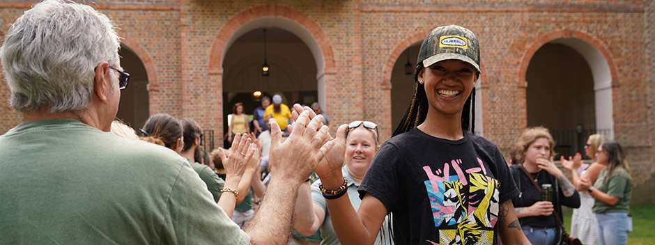Smiling employees high five as they process through the Wren Courtyard