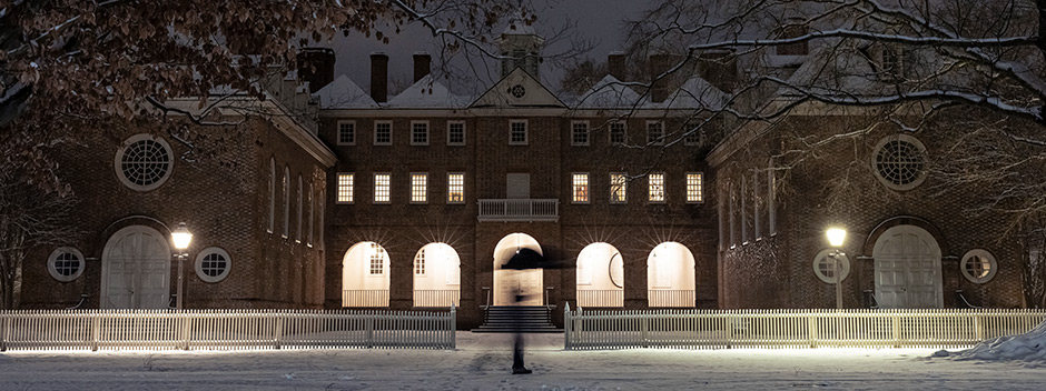 An inch of snow covers the historic Wren Courtyard at night with lampposts and the Wren Portico lit up